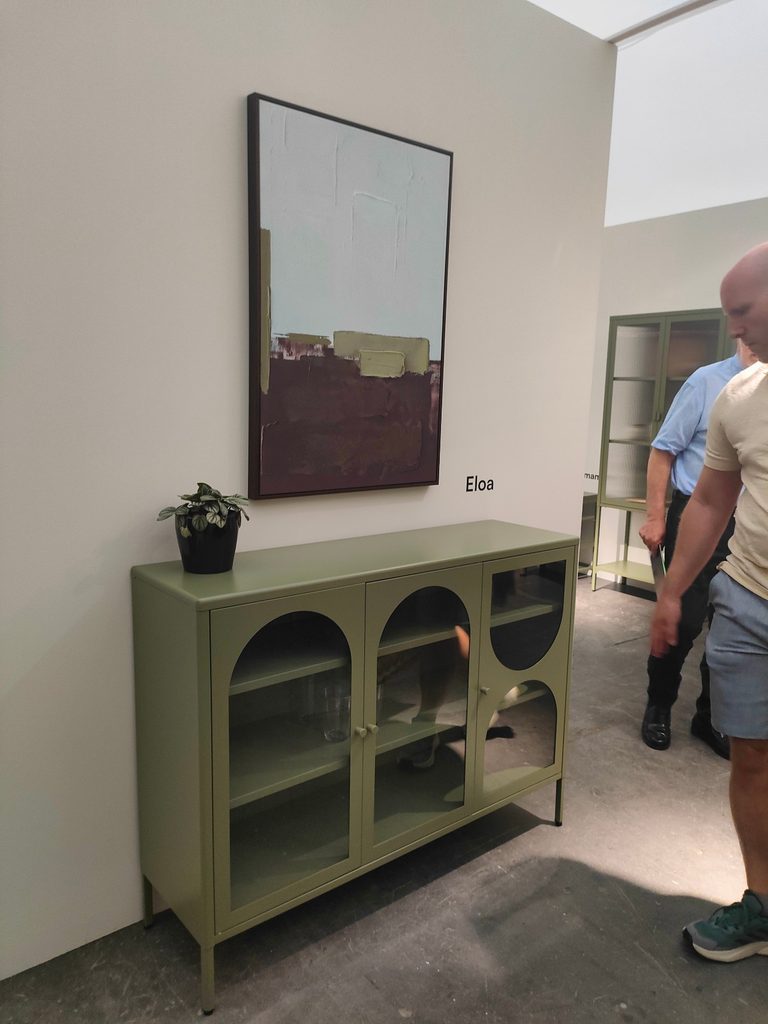 Imagen de un Stand de la Feria Hábitat València. Se muestra un aparador diseñado en chapa metálica lacado en color verde oliva apagado.
